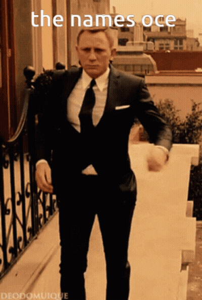 A Man In A Suit And Tie Is Walking Down Stairs With The Words The Names Oce Written Above Him GIF