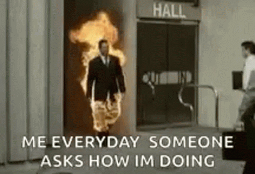 A Man In A Suit And Tie Is Walking Through A Doorway With Fire Coming Out Of It . GIF