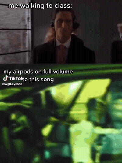 A Man In A Suit And Tie Is Walking To Class While Wearing Headphones GIF