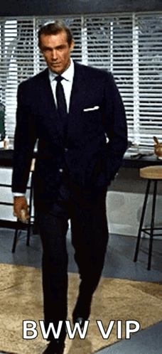A Man In A Suit And Tie Is Walking With His Hands In His Pockets And The Caption Bww Vip GIF