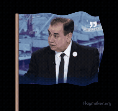 A Man In A Suit And Tie Is Waving A Flag That Says Flagmaker.org On It GIF