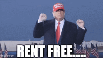 a man in a suit and tie is wearing a hat that says rent free ..