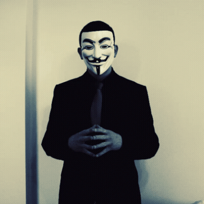 A Man In A Suit And Tie Is Wearing A Mask GIF