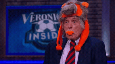 A Man In A Suit And Tie Is Wearing A Stuffed Animal Hat GIF