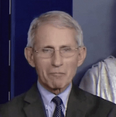 A Man In A Suit And Tie Is Wearing Glasses And Making A Funny Face . GIF