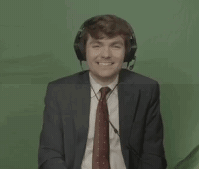 A Man In A Suit And Tie Is Wearing Headphones And A Headset . GIF
