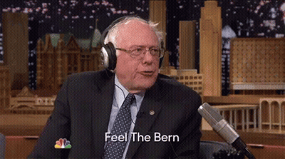 A Man In A Suit And Tie Is Wearing Headphones And Saying Feel The Bern GIF