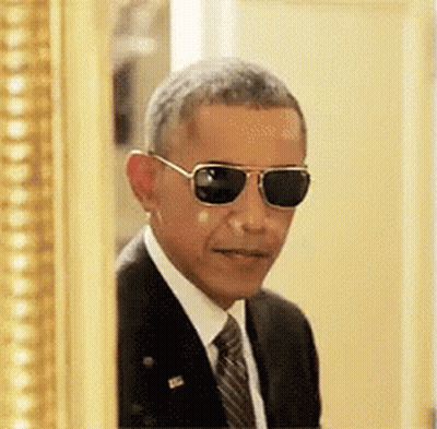 A Man In A Suit And Tie Is Wearing Sunglasses GIF