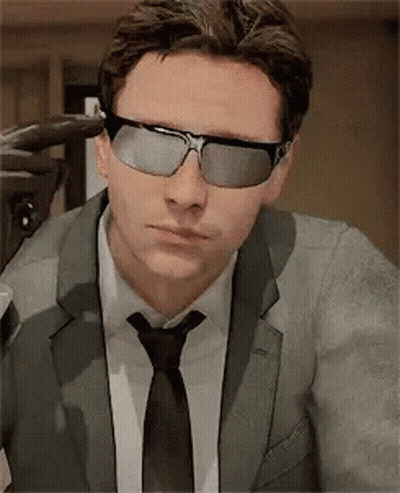 A Man In A Suit And Tie Is Wearing Sunglasses And A Tie . GIF
