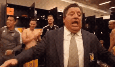 A Man In A Suit And Tie Is Yelling In A Locker Room . GIF