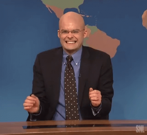 A Man In A Suit And Tie Laughs In Front Of A Snl Map GIF