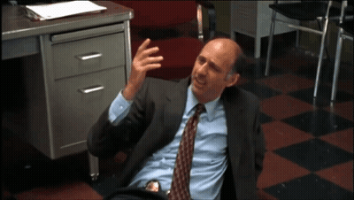 A Man In A Suit And Tie Laying On The Floor GIF