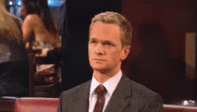 A Man In A Suit And Tie Looks At Something GIF