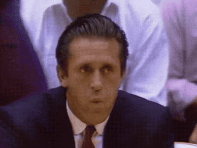A Man In A Suit And Tie Looks At Something GIF