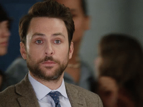 A Man In A Suit And Tie Looks At The Camera GIF