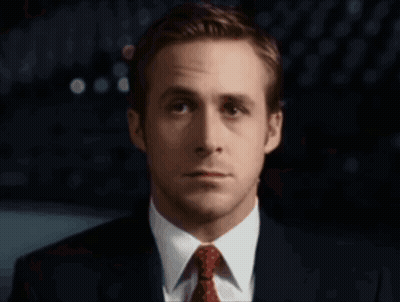 A Man In A Suit And Tie Looks At The Camera With A Serious Look On His Face GIF
