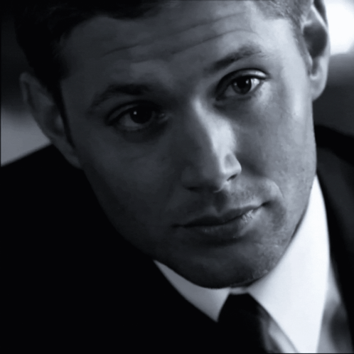 A Man In A Suit And Tie Looks At The Camera With A Serious Look On His Face GIF