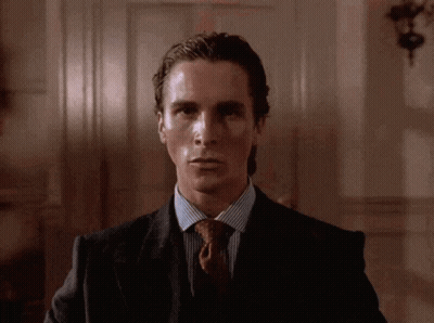 A Man In A Suit And Tie Looks At The Camera With A Serious Look On His Face GIF