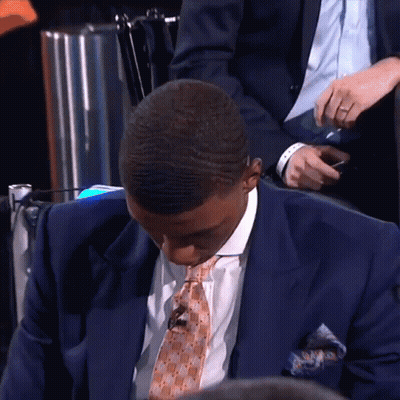 A Man In A Suit And Tie Looks Down GIF