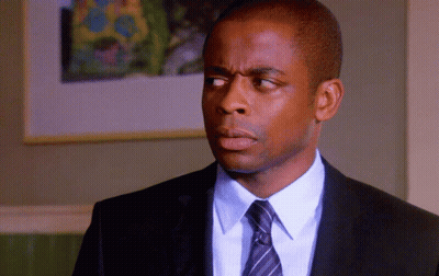 A Man In A Suit And Tie Looks To His Left GIF