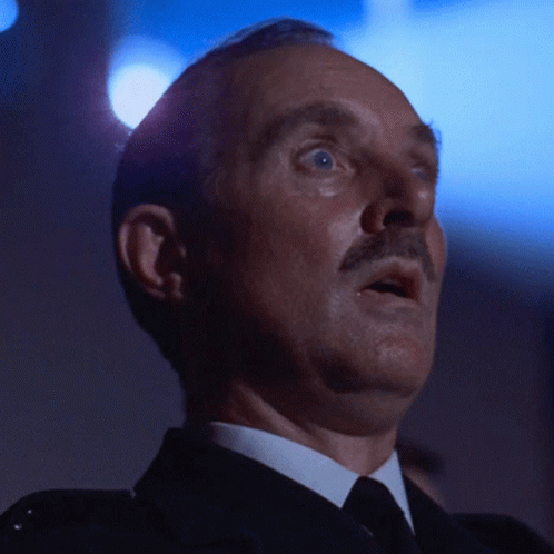 A Man In A Suit And Tie Looks Up At Something GIF