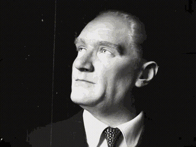 A Man In A Suit And Tie Looks Up At The Sky GIF