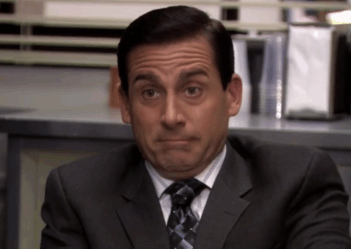 A Man In A Suit And Tie Makes A Funny Face GIF