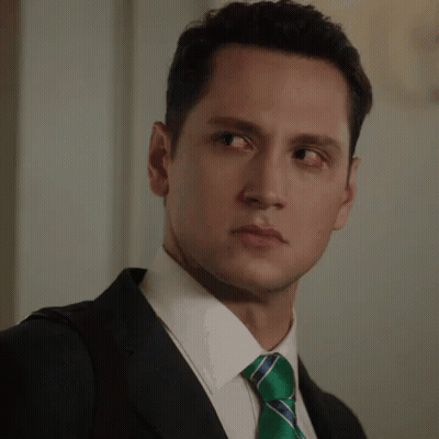 A Man In A Suit And Tie Making A Face GIF