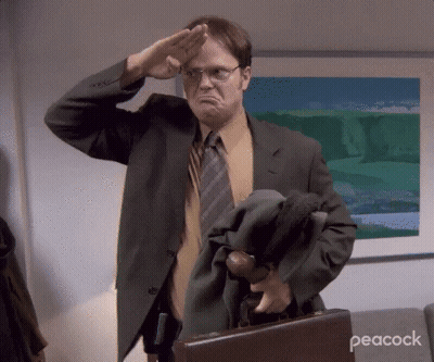 A Man In A Suit And Tie Salutes While Holding A Briefcase With Peacock Written On The Bottom GIF