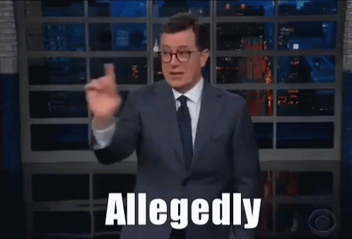A Man In A Suit And Tie Says Allegedly While Waving GIF
