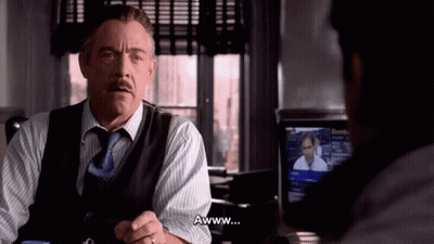 A Man In A Suit And Tie Says Awww In Front Of Another Man GIF