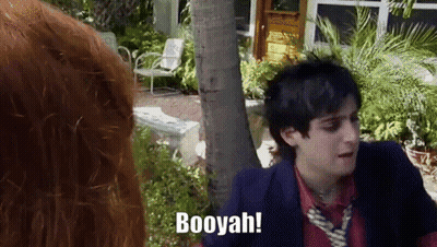 A Man In A Suit And Tie Says Booyah While Standing Next To A Woman GIF