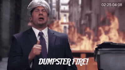 A Man In A Suit And Tie Says Dumpster Fire In Front Of A Fire GIF