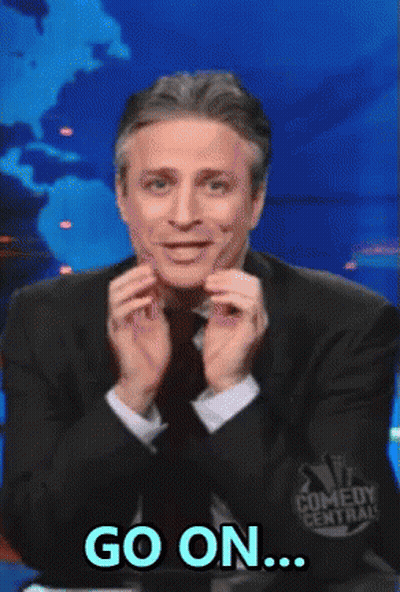 A Man In A Suit And Tie Says Go On In Front Of A Comedy Central Logo GIF