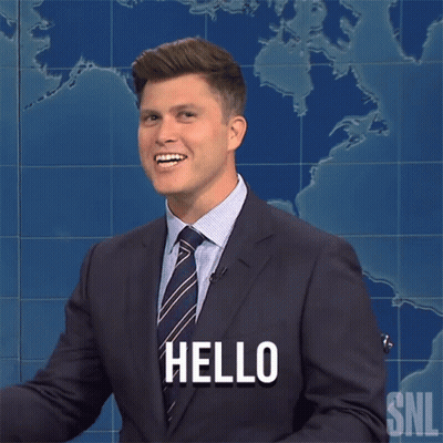 A Man In A Suit And Tie Says Hello In Front Of A Map GIF