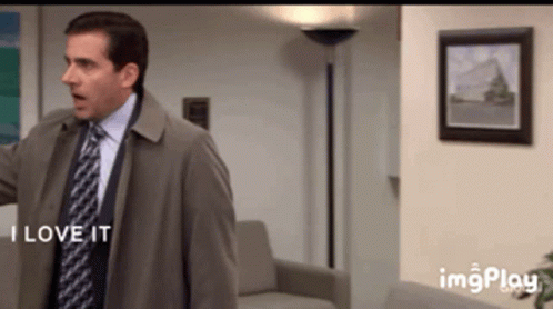 A Man In A Suit And Tie Says " I Love It " In A Living Room GIF