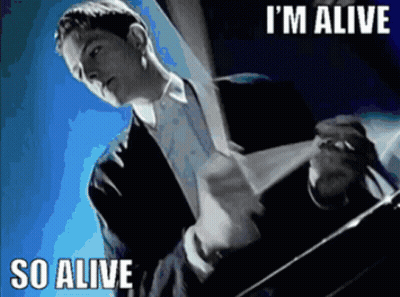 A Man In A Suit And Tie Says I 'M Alive GIF