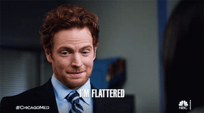 A Man In A Suit And Tie Says " I 'M Flattered " On The Screen GIF