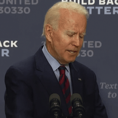 A Man In A Suit And Tie Says It 'S Hard While Standing In Front Of Microphones GIF