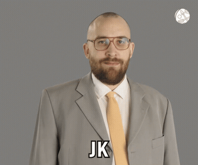 A Man In A Suit And Tie Says Jk On His Chest GIF