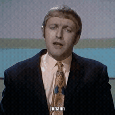 A Man In A Suit And Tie Says Johann In Front Of A Blue Background GIF