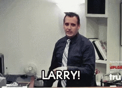 A Man In A Suit And Tie Says Larry In Front Of A Desk GIF