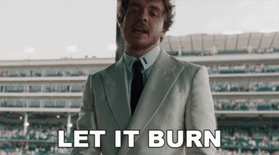 A Man In A Suit And Tie Says Let It Burn In Front Of A Stadium GIF