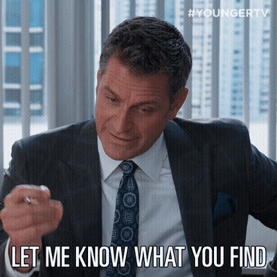 A Man In A Suit And Tie Says " Let Me Know What You Find " While Pointing At Something GIF