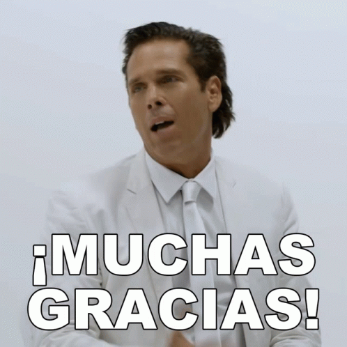 A Man In A Suit And Tie Says Muchas Gracias In Spanish GIF