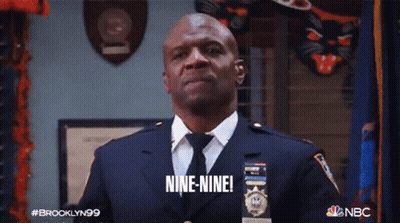 A Man In A Suit And Tie Says Nine Nine GIF