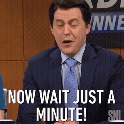 A Man In A Suit And Tie Says " Now Wait Just A Minute ! " GIF