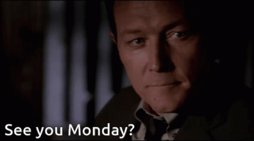 A Man In A Suit And Tie Says " See You Monday " In A Dark Room GIF
