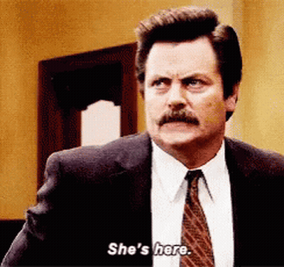 A Man In A Suit And Tie Says She 'S Here . GIF