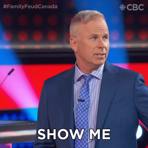 A Man In A Suit And Tie Says Show Me In Front Of A Microphone GIF